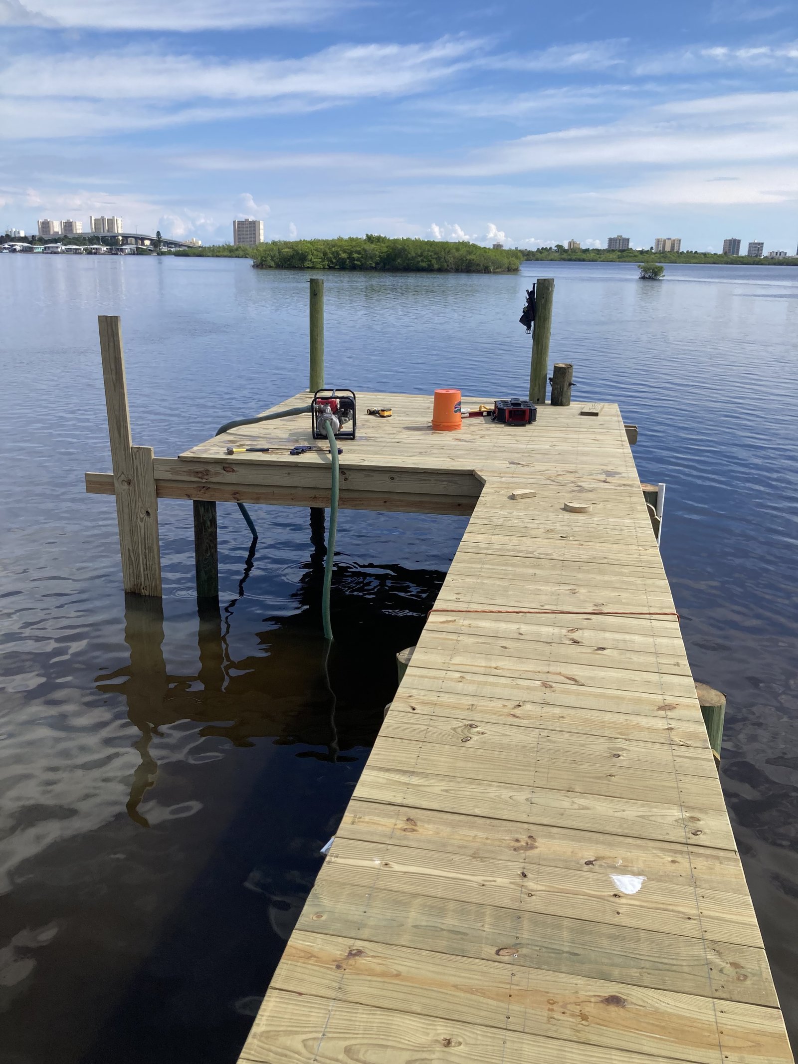 Freshly built dock platform extending over open Florida waterway with city skyline beyond